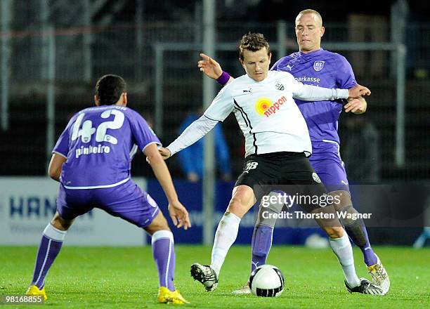 Regis Dorn of Sandhausen battles for the ball with Ricky Pinheiro and Tobias Nickenig of Osnabrueck during the 3. Liga match between SV Sandhausen...