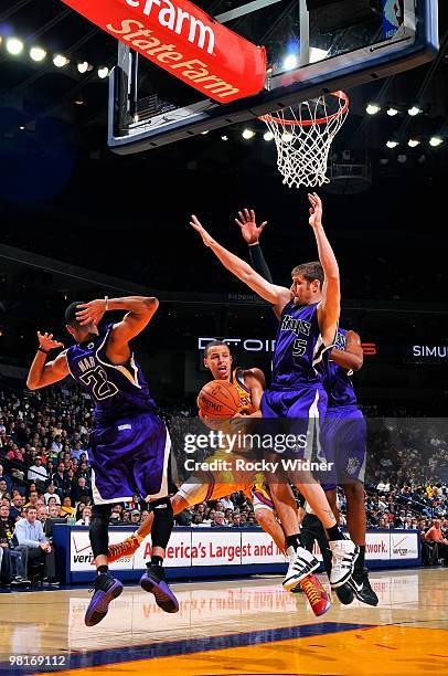 Stephen Curry of the Golden State Warriors passes the ball around Kevin Martin and Andres Nocioni of the Sacramento Kings during the game on February...