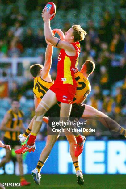 Tom Lynch of the Suns marks the ball against Ricky Henderson and James Frawley of the Hawks during the round 14 AFL match between the Hawthorn Hawks...