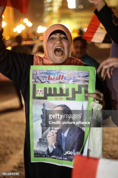 Dpatop - A woman chants slogans while holding a poster of Egyptian President Abdel-Fattah al-Sisi during celebrations after his re-election for a...