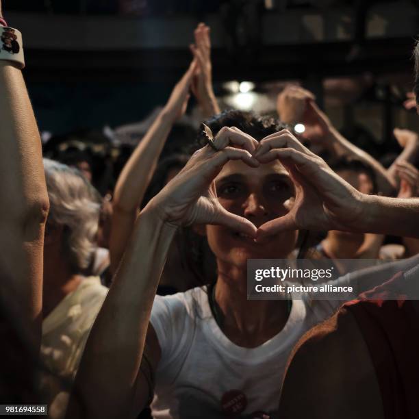 April 2018, Brazil, Rio de Janeiro: A supporter of Luiz Inacio Lula da Silva, former president of Brazil, forming a heart shape with her hands at a...