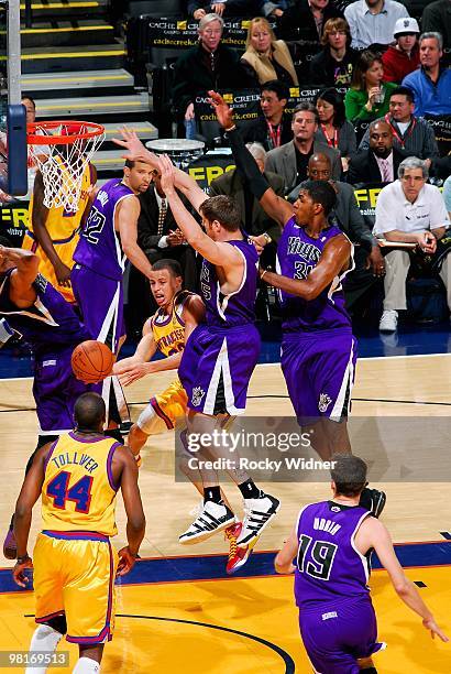 Stephen Curry of the Golden State Warriors passes the ball around Andres Nocioni and Jason Thompson of the Sacramento Kings during the game on...