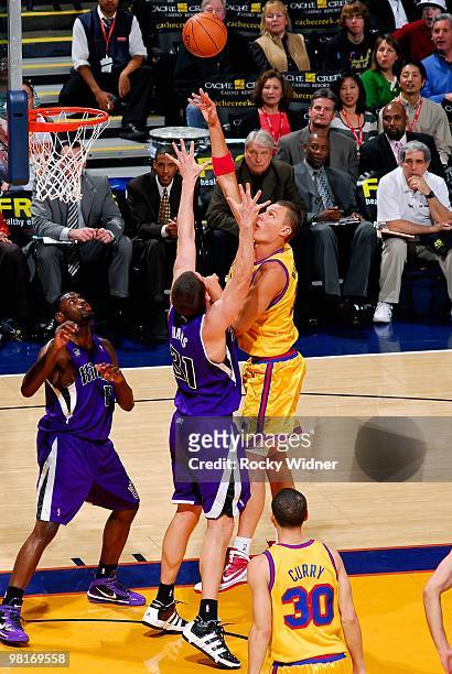 Andris Biedrins of the Golden State Warriors puts a shot up over Spencer Hawes of the Sacramento Kings during the game on February 17, 2009 at Oracle...