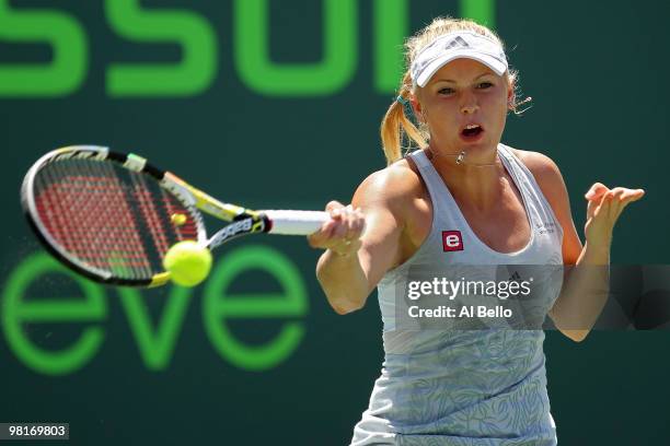 Caroline Wozniacki of Denmark returns a shot against Justine Henin of Belgium during day nine of the 2010 Sony Ericsson Open at Crandon Park Tennis...