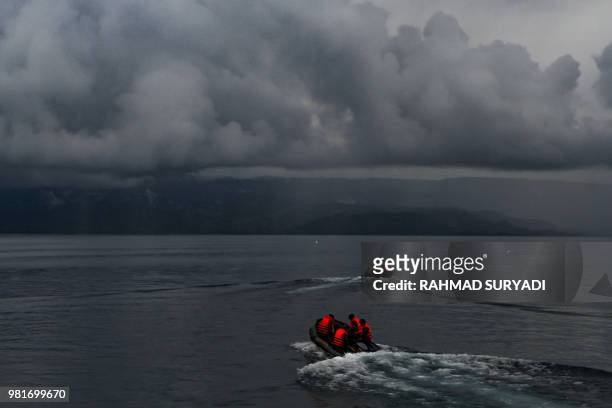 Indonesian rescue team officers conduct a search operation for the missing victims of capsized ferry at Lake Toba, in North Sumatra province, on June...