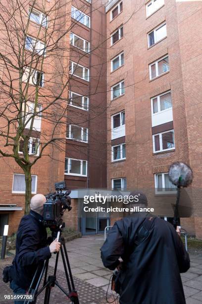 March 2018, Germany, Hannover: A cameraman in front of an apartment house in the district Gross-Buchholz, where two dead people were found. A dog...