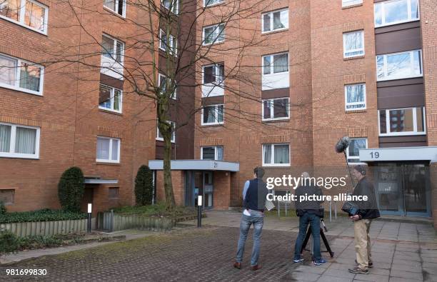 March 2018, Germany, Hannover: A cameraman in front of an apartment house in the district Gross-Buchholz, where two dead people were found. A dog...