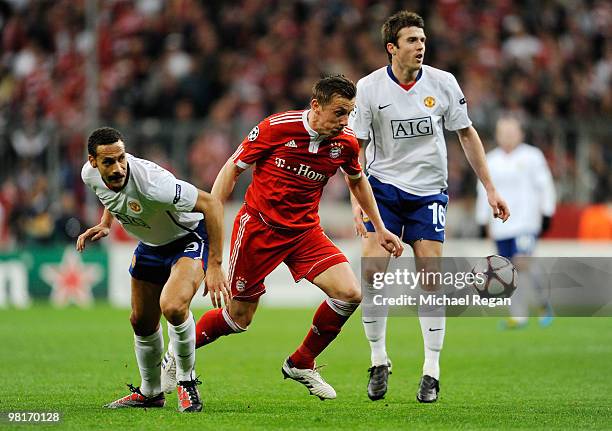 Franck Ribery of Bayern Muenchen is challenged by Rio Ferdinand and Michael Carrick of Manchester United during the UEFA Champions League quarter...