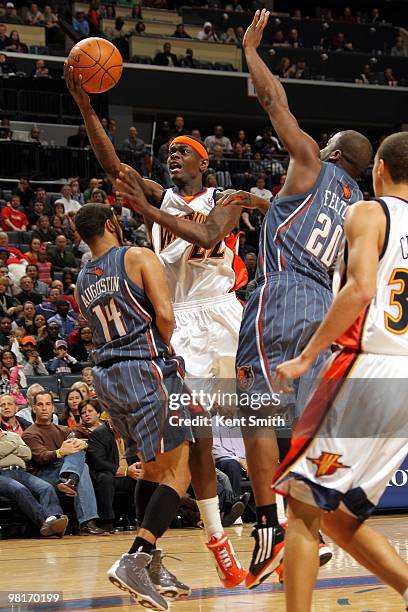 Anthony Morrow of the Golden State Warriors shoots a layup against D.J. Augustin and Raymond Felton of the Charlotte Bobcats during the game at Time...