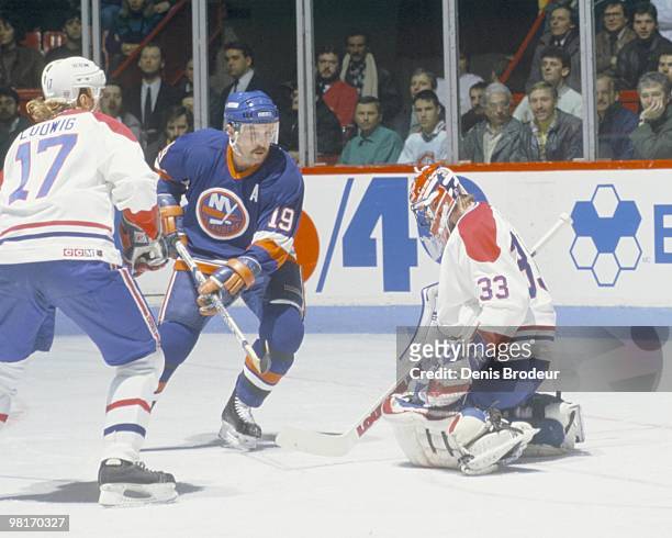 Bryan Trottier of the New York Islanders skates against Patrick Roy and Craig Ludwig of the Montreal Canadiens in the 1980's at the Montreal Forum in...