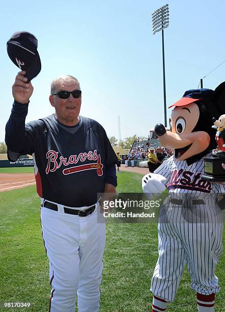 In this handout photo provided by Disney, With Mickey Mouse at his side, Atlanta Braves manager Bobby Cox acknowledges the crowd at ESPN Wide World...