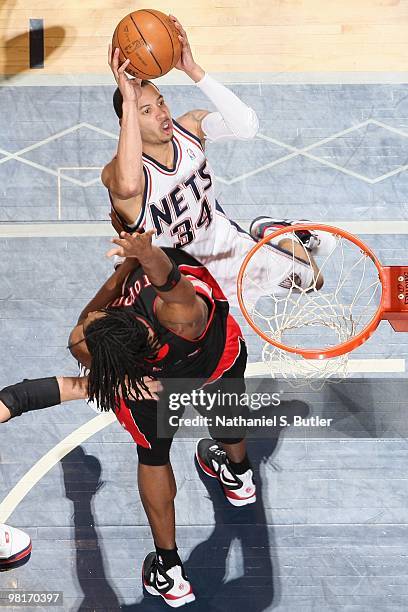 Devin Harris of the New Jersey Nets goes to the basket against Chris Bosh of the Toronto Raptors during the game on March 20, 2010 at the Izod Center...