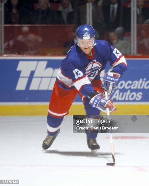 Teemu Selanne of the Winnipeg Jets skates with the puck against the Montreal Canadiens in the early 1990's at the Montreal Forum in Montreal, Quebec,...