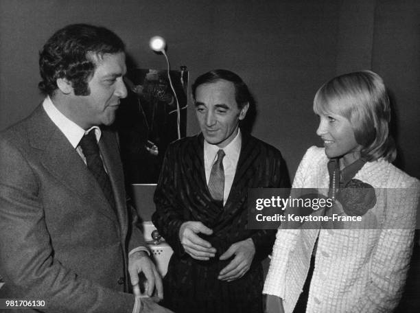 Dans la loge à l'Olympia, le comédien Jean Yanne, Charles Aznavour et sa femme Ulla, à Paris, France, le 16 novembre 1972.