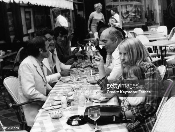 Charles Aznavour, en face, Eddie Barclay, Ulla Aznavour et sur ses genoux sa fille Katia lors d'un déjeuner chez Eddie Barclay, à Cannes, France, le...