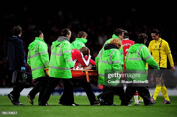 The injured William Gallas of Arsenal holds his head in his hands as he is carried off the pitch on a stretcher during the UEFA Champions League...