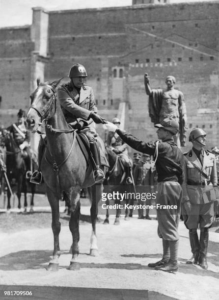 Benito Mussolini récompense un jeune fasciste avanguardisti lors du 18ème anniversaire de l'entrée en guerre de l'Italie à Rome en Italie.