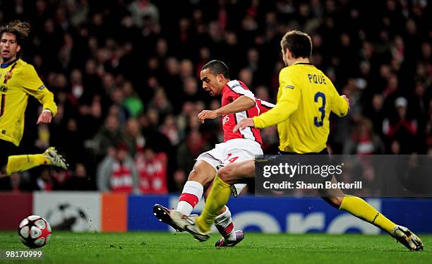 Theo Walcott of Arsenal shoots past Gerard Pique of Barcelona to score a goal during the UEFA Champions League quarter final first leg match between...