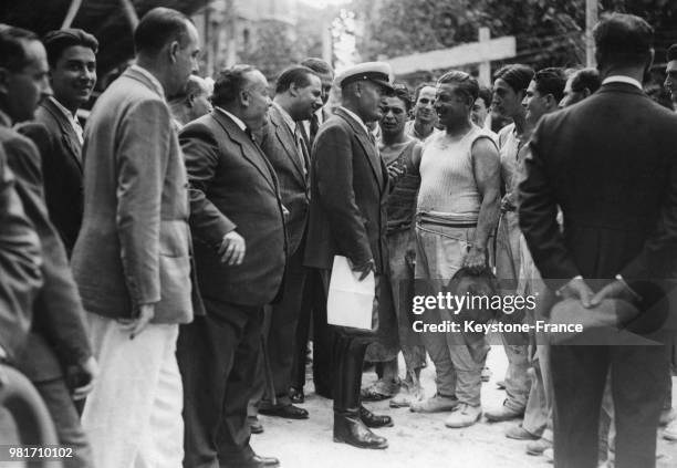 Benito Mussolini s'entretient avec un ouvrier sur le chantier de la cité universitaire à Rome en Italie.