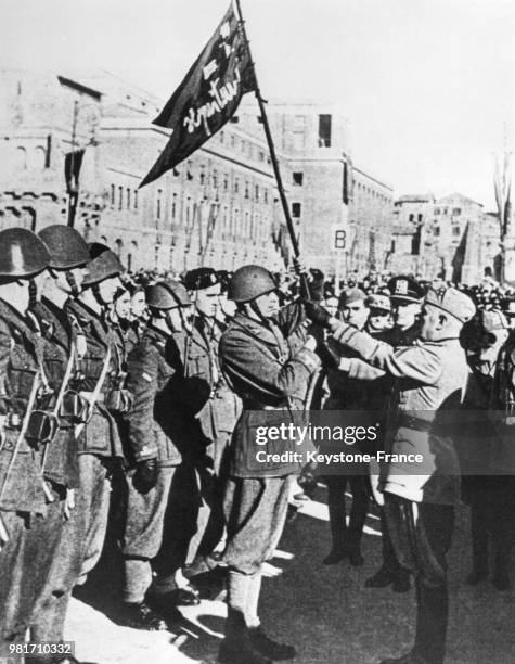 Benito Mussolini remet un drapeau, symbolisant la valeur militaire, à une unité de la division M, en Italie.