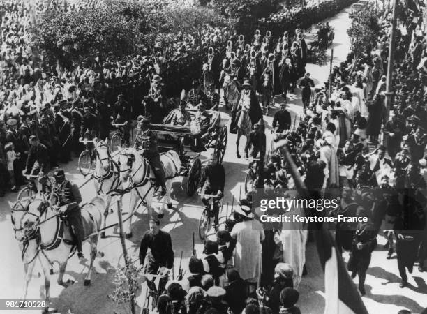 Benito Mussolini, accompagné par le gouverneur le maréchal Italo Balbo, arrive en calèche à l'exposition de Tripoli, lors de son voyage en Libye,...