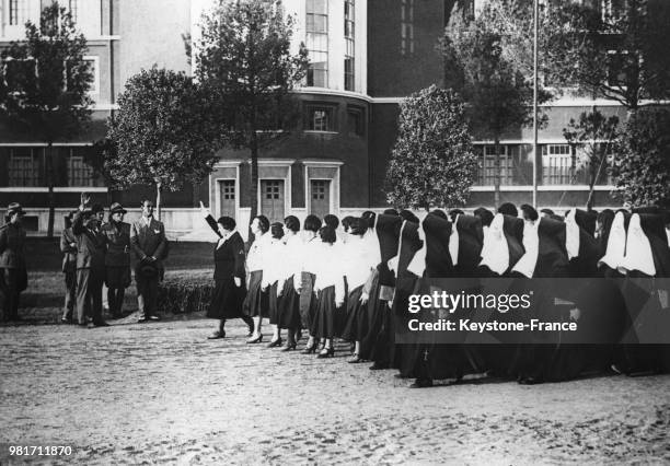 Défilé de femmes fascistes, accompagnées de religieuses, lors de la fête de la gymnastique à Rome en Italie, le 23 juillet 1933.