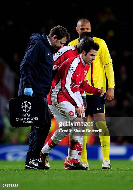 Cesc Fabregas of Arsenal hobbles off the pitch injured to receive treatment after levelling the scores at 2-2 from the penalty spot during the UEFA...