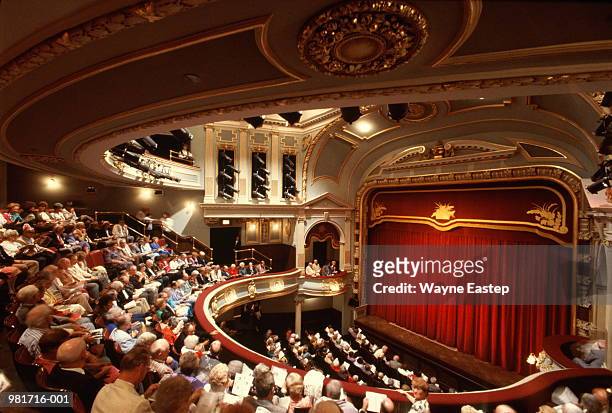 interior of theatre, audience waiting for performance to start - theater stock-fotos und bilder
