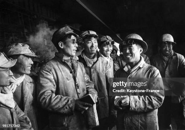 Suivant les préceptes de Mao, des travailleurs discutent de leurs progrès en production dans une fonderie d'acier en Chine, le 23 avril 1968.