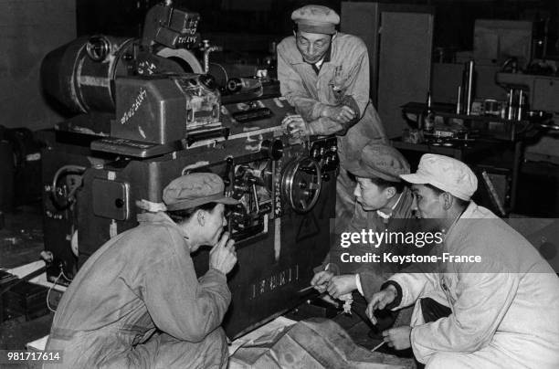 Ouvriers devant la machine qu'ils ont construite à l'usine de fabrication de machines-outils à Shanghai en Chine, le 22 juillet 1966.