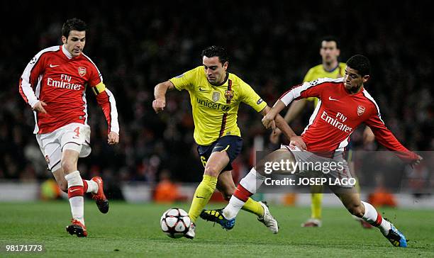 Barcelona's Spanish midfielder Xavi Hernandez vies with Arsenal's Spanish midfielder Cesc Fabregas and Brazilian midfielder Denilson during their...