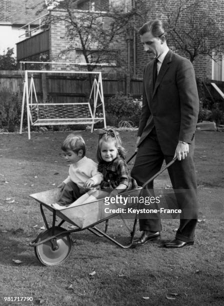 Graham Hill joue avec ses enfants Damon Hill et Brigitte Hill, au Royaume-Uni, circa 1962.