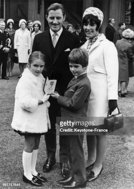 Graham Hill, entouré de ses enfants Brigitte Hill et Damon Hill et de sa femme Bette Hill, a été décoré de l'ordre de l'Empire britannique au palais...