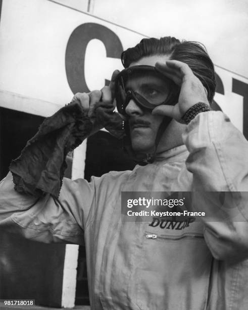 Graham Hill mettant ses lunettes de protection avant les essais en Angleterre au Royaume-Uni.