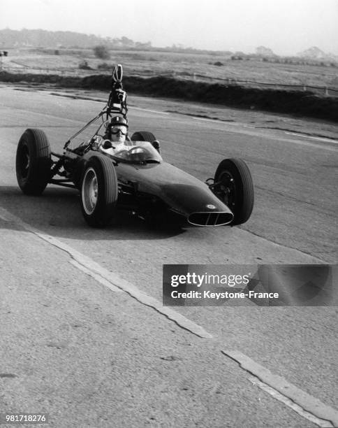 Graham Hill pilotant une voiture BRM équipée d'une caméra et d'un enregistreur de son de la BBC fixé sur sa poitrine sur le circuit de Snetterton en...