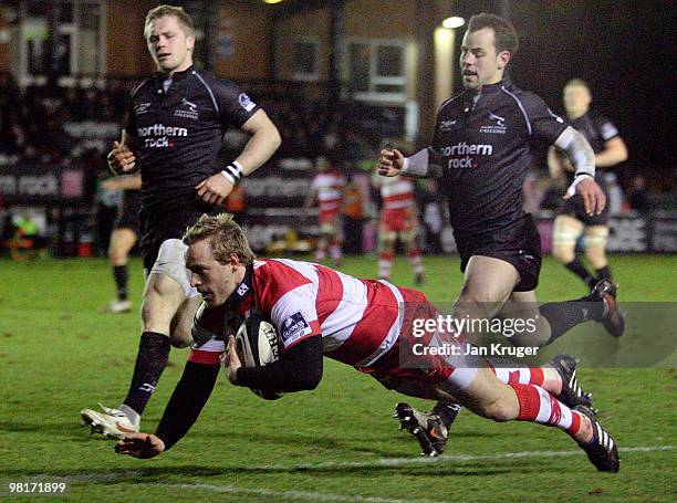 Tim Taylor of Gloucester goes over for his try ahead of Alex Tait of Newcastle during the Guinness Premiership match between Newcastle Falcons and...