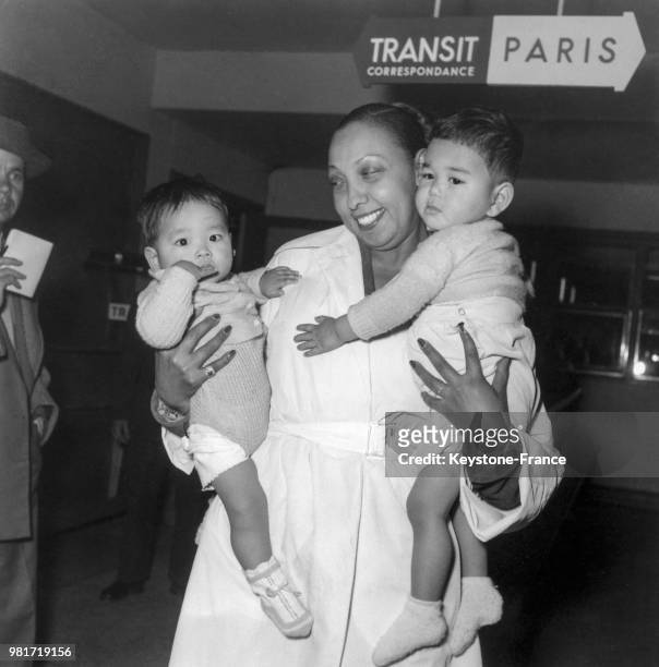 De retour d'une touréne au Japon, Joséphine Baker avec deux enfants adoptés, Automne et Lumière, arrivant à Orly en France, le 12 mai 1954.