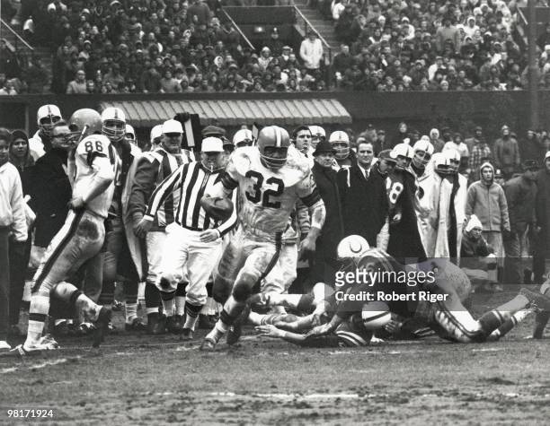 Jim Brown of the Cleveland Browns carries the ball against the Baltimore Colts during the 1964 NFL Championship game at Cleveland Stadium on December...