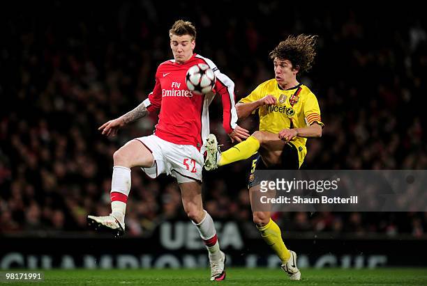 Nicklas Bendtner of Arsenal is tackled by Carles Puyol of Barcelona during the UEFA Champions League quarter final first leg match between Arsenal...