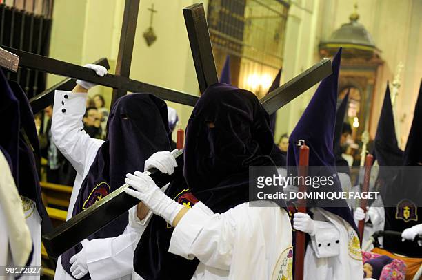 Penitents hold crosses and candles as they take part in the ''Nuestro Padre Jesus de la Salud" brotherhood procession during the Holy Week in Madrid...