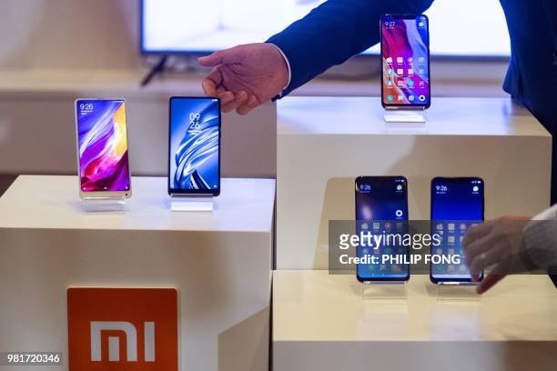 Products by Chinese smartphone maker Xiaomi are displayed during a press conference for the company's initial public offering in Hong Kong on June...
