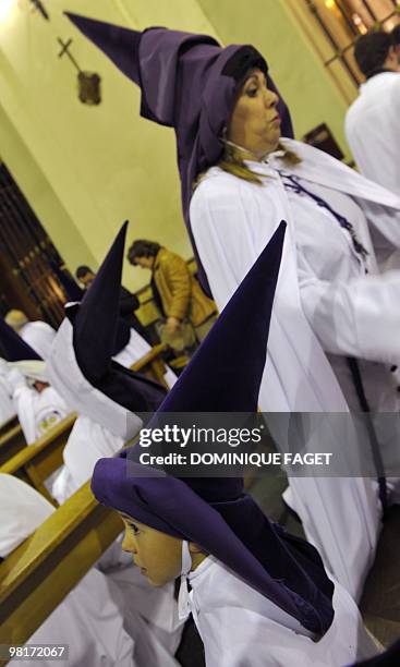 Young penitent looks on before taking part in the ''Nuestro Padre Jesus de la Salud" brotherhood procession during the Holy Week in Madrid on March...