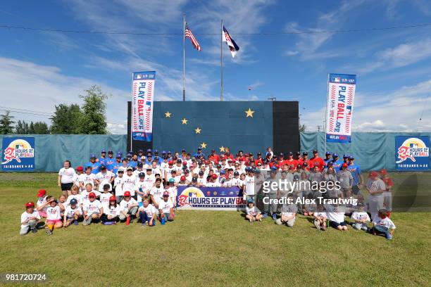 Participants pose for a photo following the first session of a PLAYBALL event at the 113th Midnight Sun Game between American Legion Post 30 and...