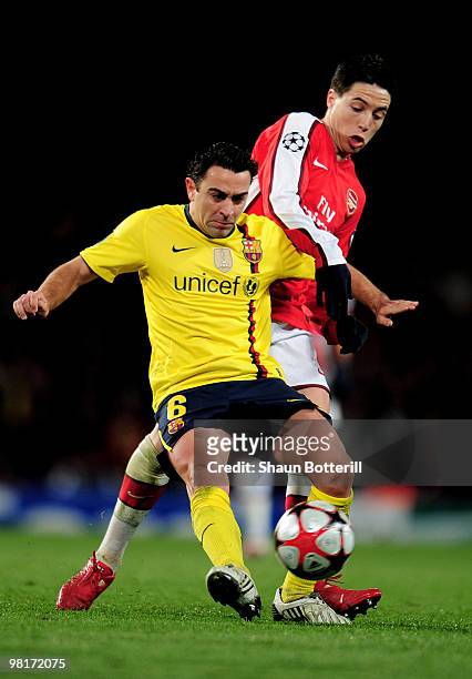Xavi Hernandez of Barcelona is challenged by Samir Nasri of Arsenal during the UEFA Champions League quarter final first leg match between Arsenal...