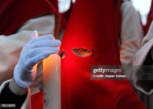 Young penitent of the Cofradia del Silencio protects his candles from the wind during a Holy Week procession on March 31, 2010 in Zamora, Spain....