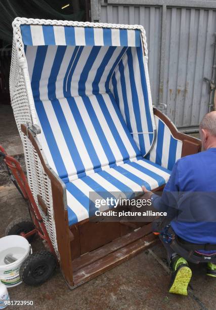 April 2018, Germany, Binz: Employees of the company Baland beach chair letting transport the first beach chairs to the Baltic Sea beach for the new...