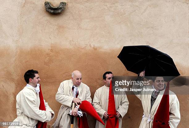 Penitent of the Cofradia del Silencio uses an umbrella to protect himself from the rain pior to a Holy Week procession on March 31, 2010 in Zamora,...