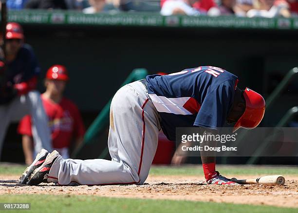 Cristian Guzman of the Washington Nationals reacts after an awkward swing against the St Louis Cardinals at Roger Dean Stadium on March 31, 2010 in...