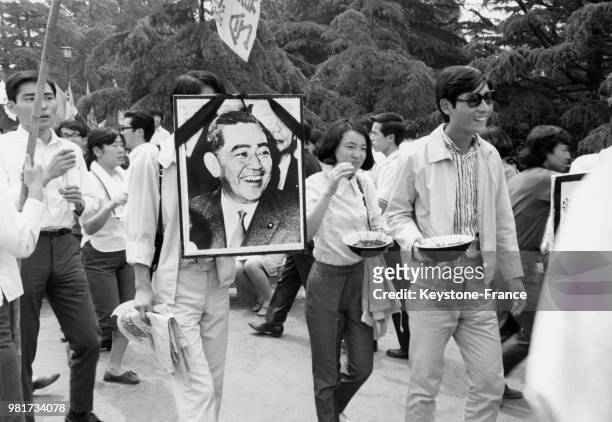 Etudiants, ouvriers et pacifistes, dont un portant la photographie du premier ministre Eisaku Sato décédé, lors d'une manifestation contre la guerre...