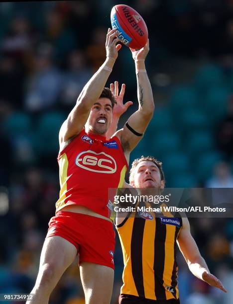 Alex Sexton of the Suns and Blake Hardwick of the Hawks compete for the ball during the 2018 AFL round 14 match between the Hawthorn Hawks and the...